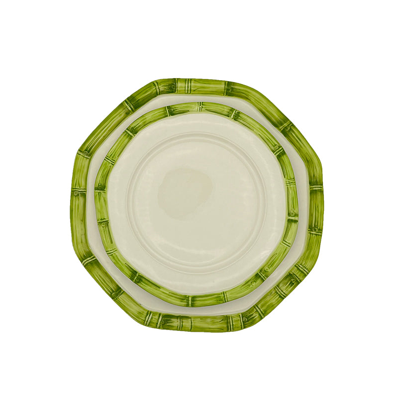 Nina Campbell stacked ceramic plates with hand painted bamboo design on edge in green against white background