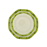 Nina Campbell stacked ceramic plates with hand painted bamboo design on edge in green against white background