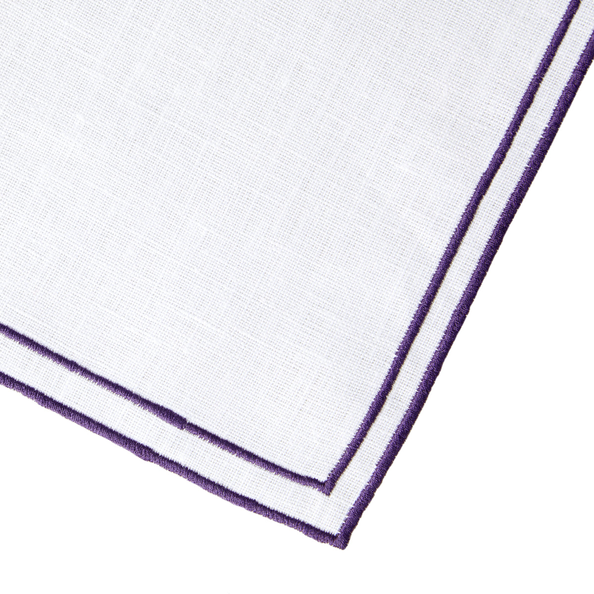 Nina Campbell Linen Napkin White/Aubergine against a white background close up