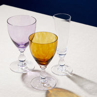 Nina Campbell Jewel Large Wine Glass Topaz with other glassware on table