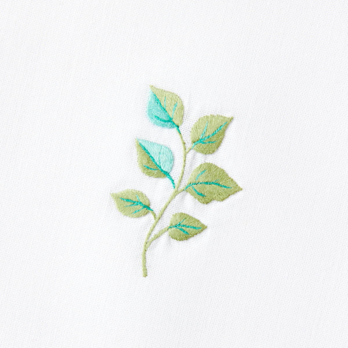 Nina Campbell cocktail napkin / coaster aqua leaf on white background close up