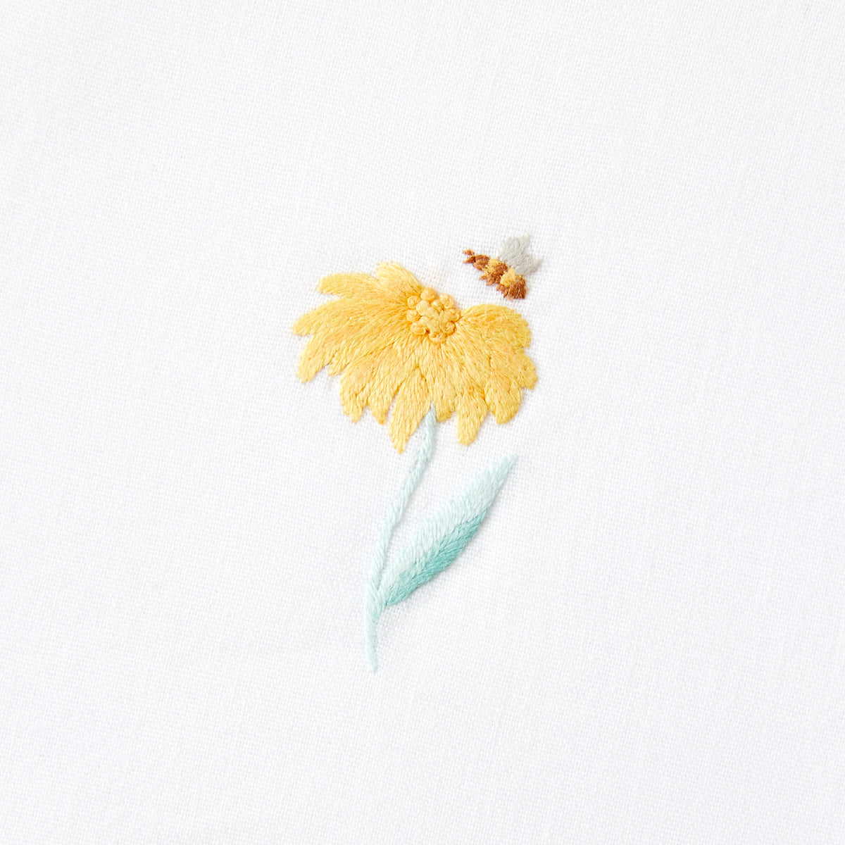 Nina Campbell cocktail napkin / coaster yellow flower on white background close up