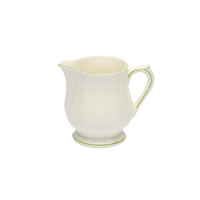 White ceramic creamer with green accents on a white background