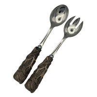 Nina Campbell stainless steel serving set with ceramic handles resembling leaves painted in brown on white background