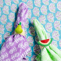 Nina Campbell Raffia Napkin Ring Green Pear on purple napkin and watermelon napkin ring on green napkin