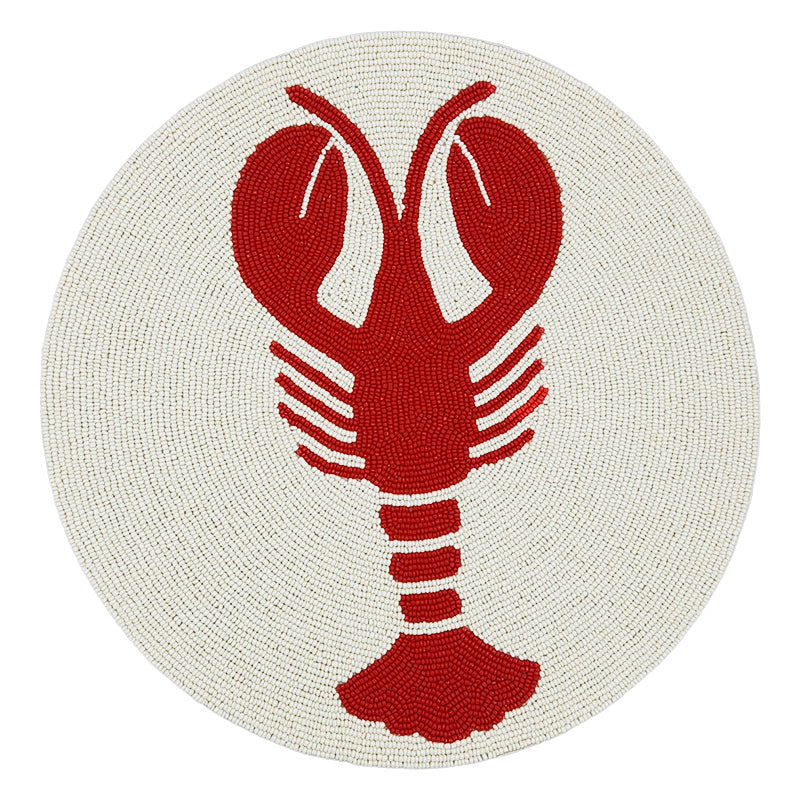 Nina Campbell circular beaded placemat with a cream background and red lobster on white background