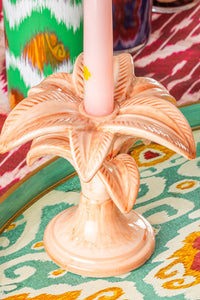 Nina Campbell ceramic small palm candlestick holder painted in pink on a colourful tablecloth