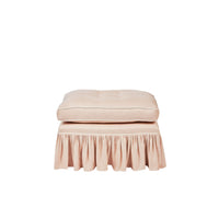 Nina Campbell pink fabric stool with frilled skirt against a white background