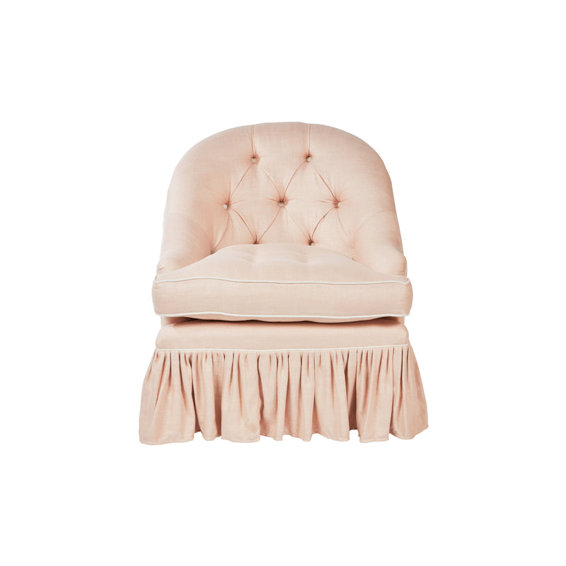 Nina Campbell pink fabric chair with frilled skirt against a white background