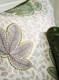 Close up of Nina Campbell Athena Clarice Pebble/Emerald/Chocolate fabric on cushion