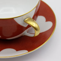 Nina Campbell Heart Breakfast cup handle detail in Coq de Roche colour on white background. 