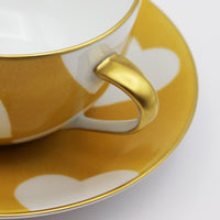 Nina Campbell Heart Breakfast cup and saucer handle detail in Jaune colour on white background. 