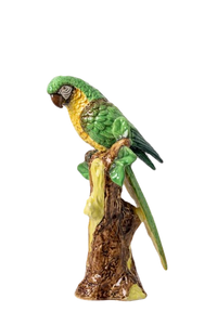 Nina Campbell ceramic parrot perched on branch in greens and yellows