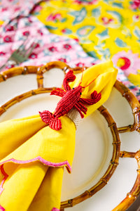 Nina Campbell Raffia Napkin Ring Red Lobster on yellow napkin table setting