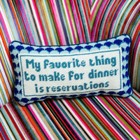 Nina Campbell Needlepoint Cushion Reservations against a couch